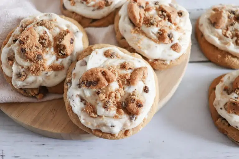 Cookie frosted chocolate chip cookies on a wooden board.