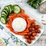 garlic dipping sauce in a bowl with veggies on the side