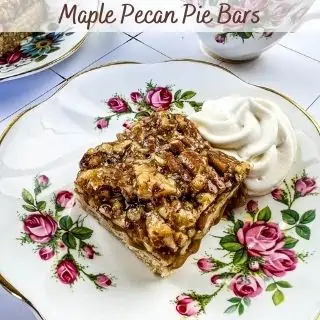 Maple Pecan Pie Bar on a plate with whipped cream.