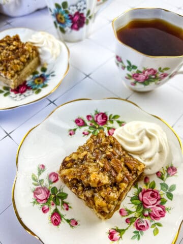 maple pecan pie bars with a cup of tea in the background