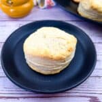 flaky smoked biscuits on a plate with more biscuits in the background