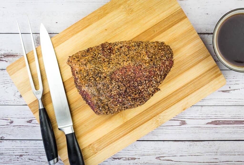smoked eye of round resting on a cutting board