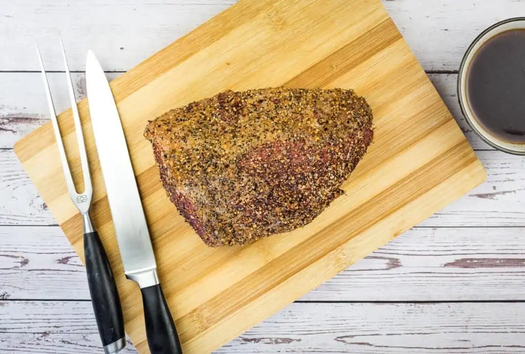 smoked eye of round resting on a cutting board