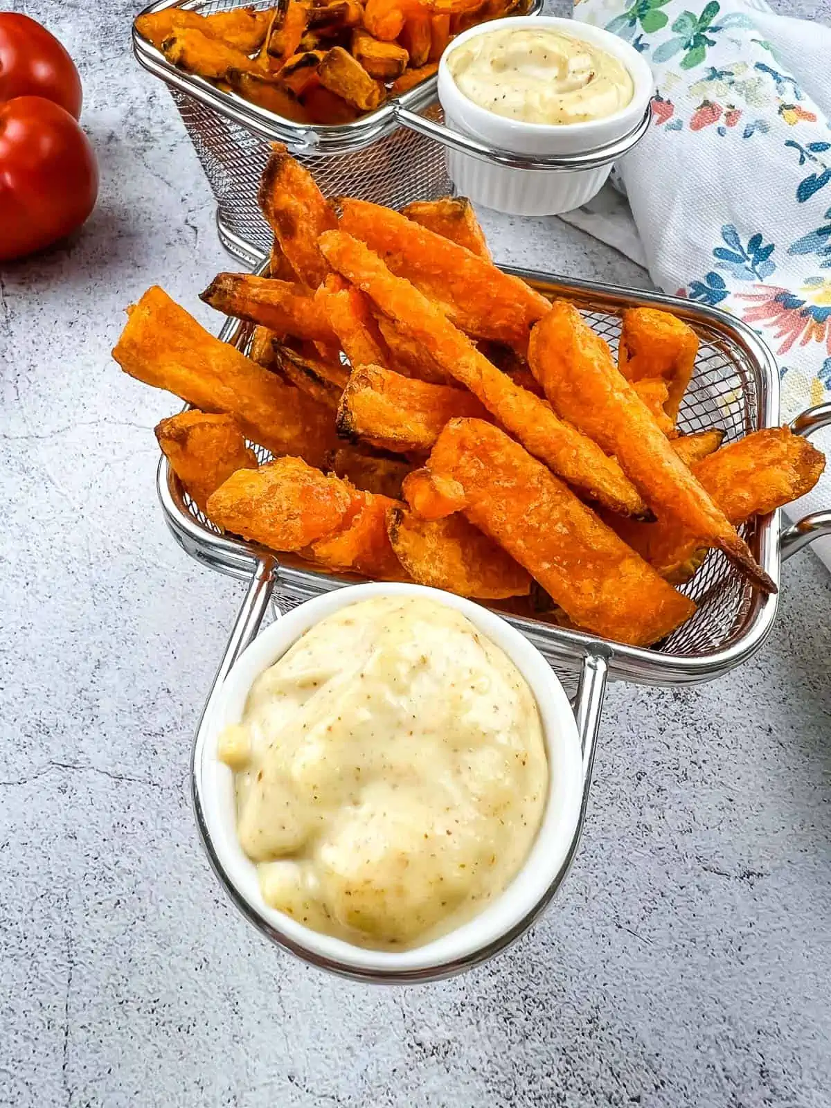 spicy garlic aioli in a dipping cup with sweet potato fries