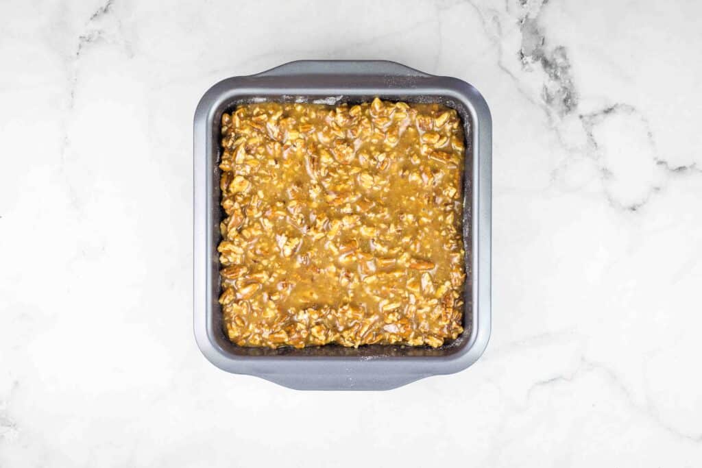 maple pecan pie bars in a baking dish ready for the oven.