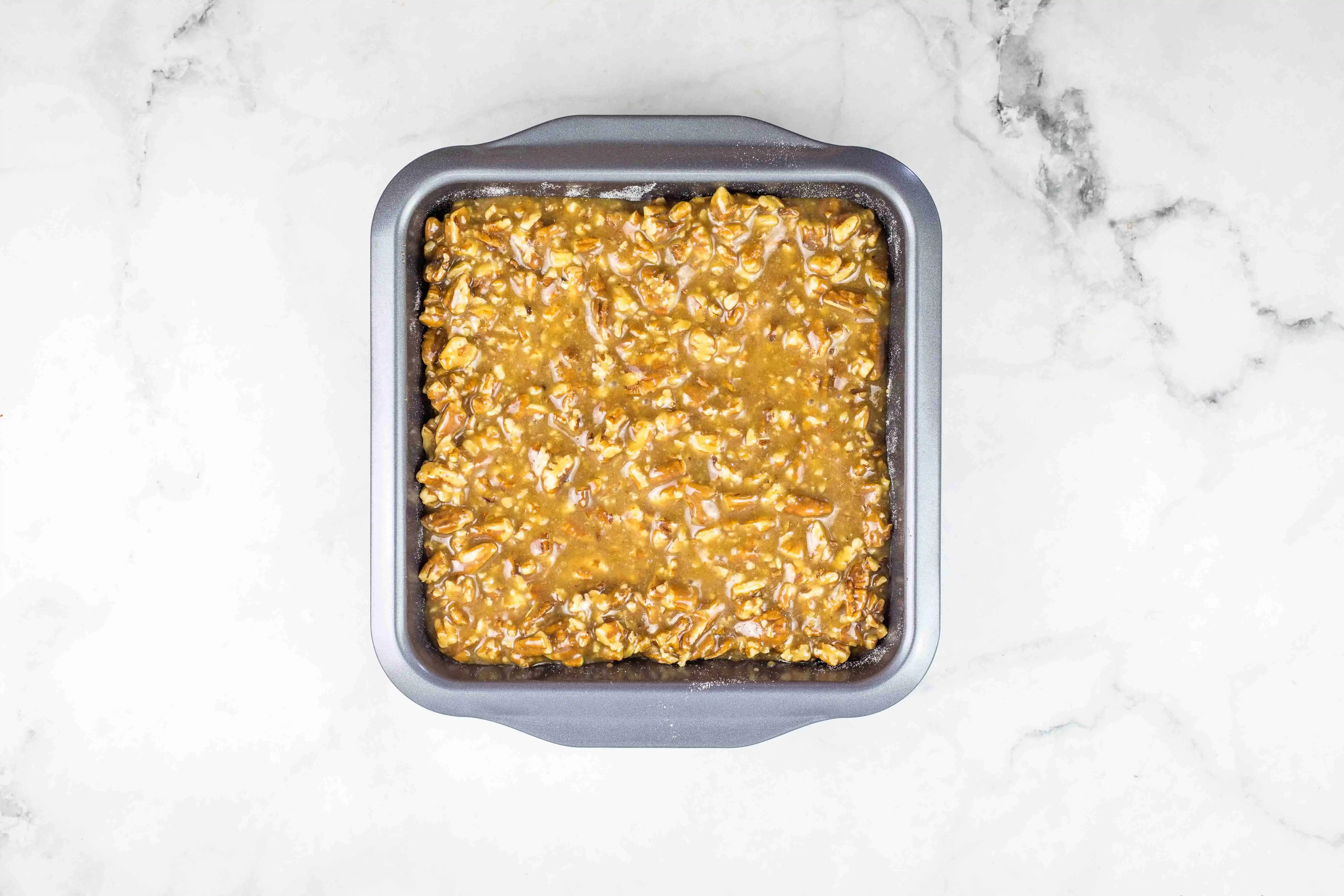 maple pecan pie bars in a baking dish ready for the oven.