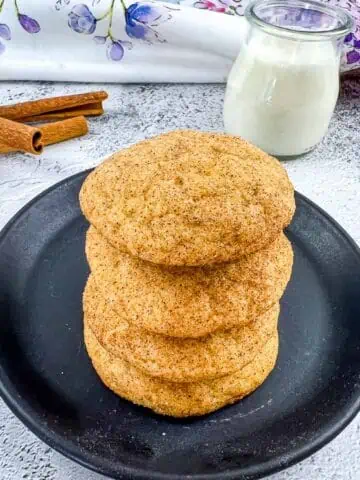 pumpkin snickerdoodles stacked on a plate next to milk