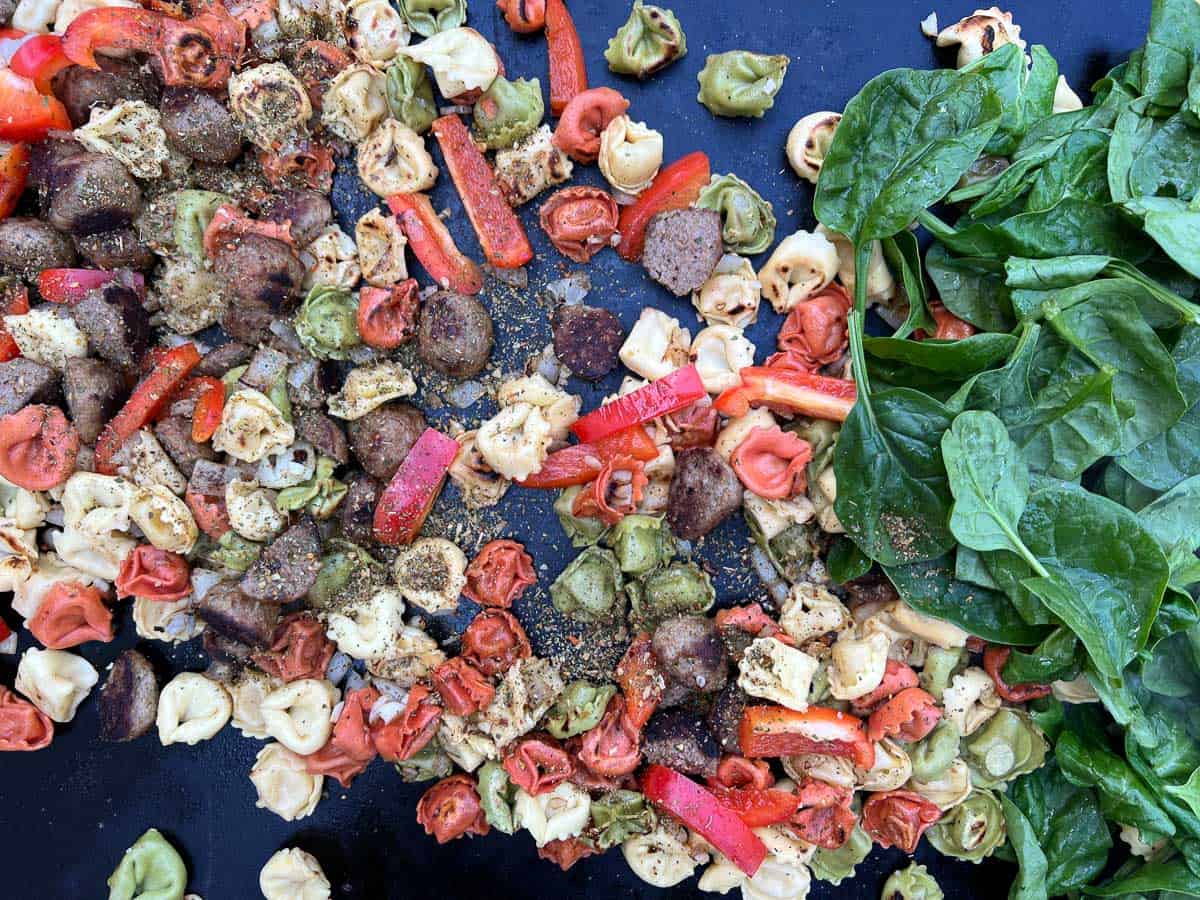spinach, tomatoes, and seasoning added to tortellini and meatballs.