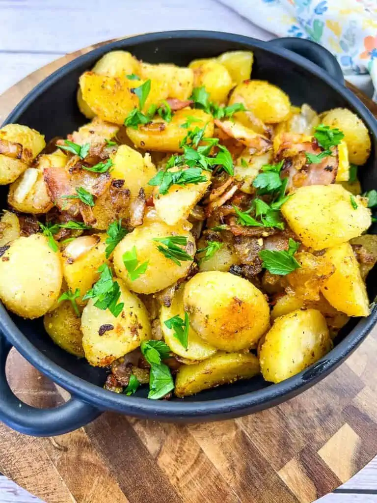 blackstone fried potatoes in a black dish on a cutting board