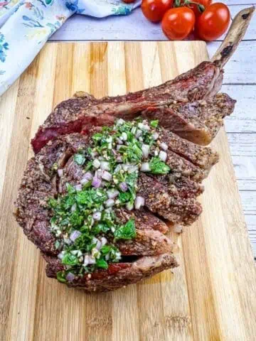 smoked tomahawk steak on a cutting board