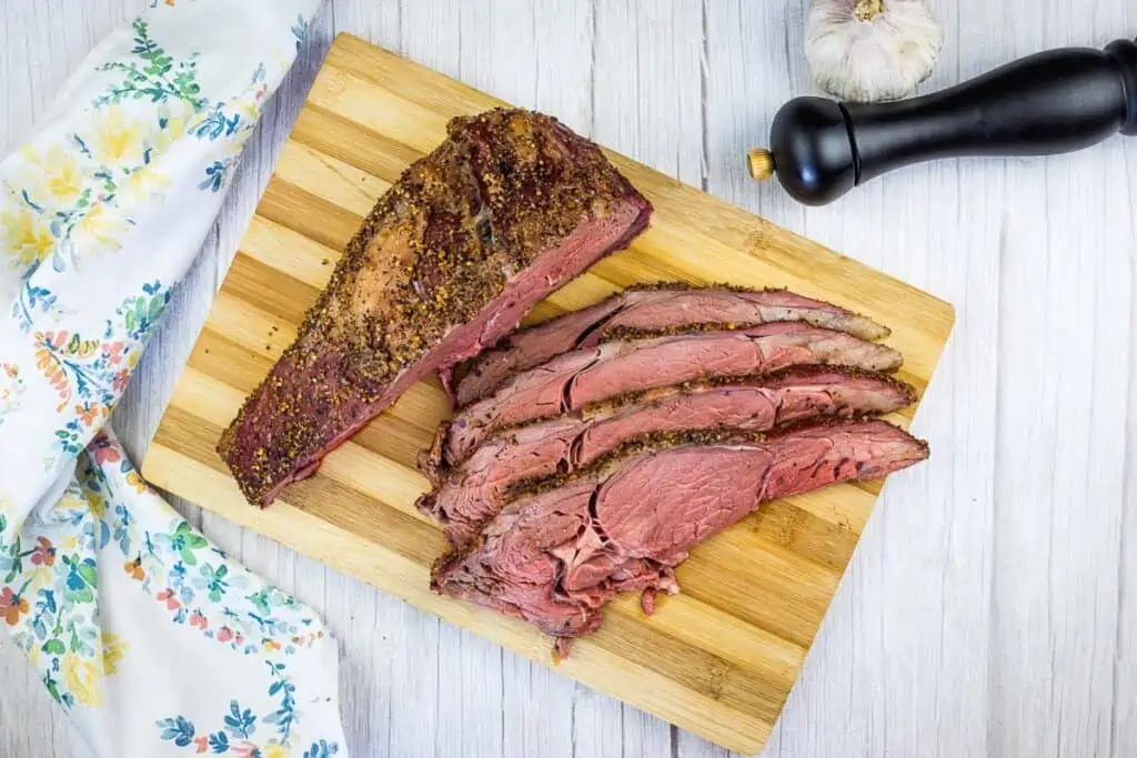 sliced smoked ribeye roast on a cutting board
