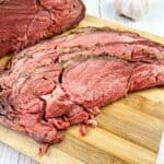 sliced smoked ribeye roast on a cutting board