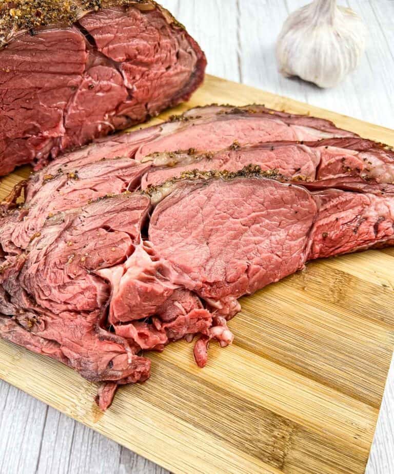 sliced smoked ribeye roast on a cutting board