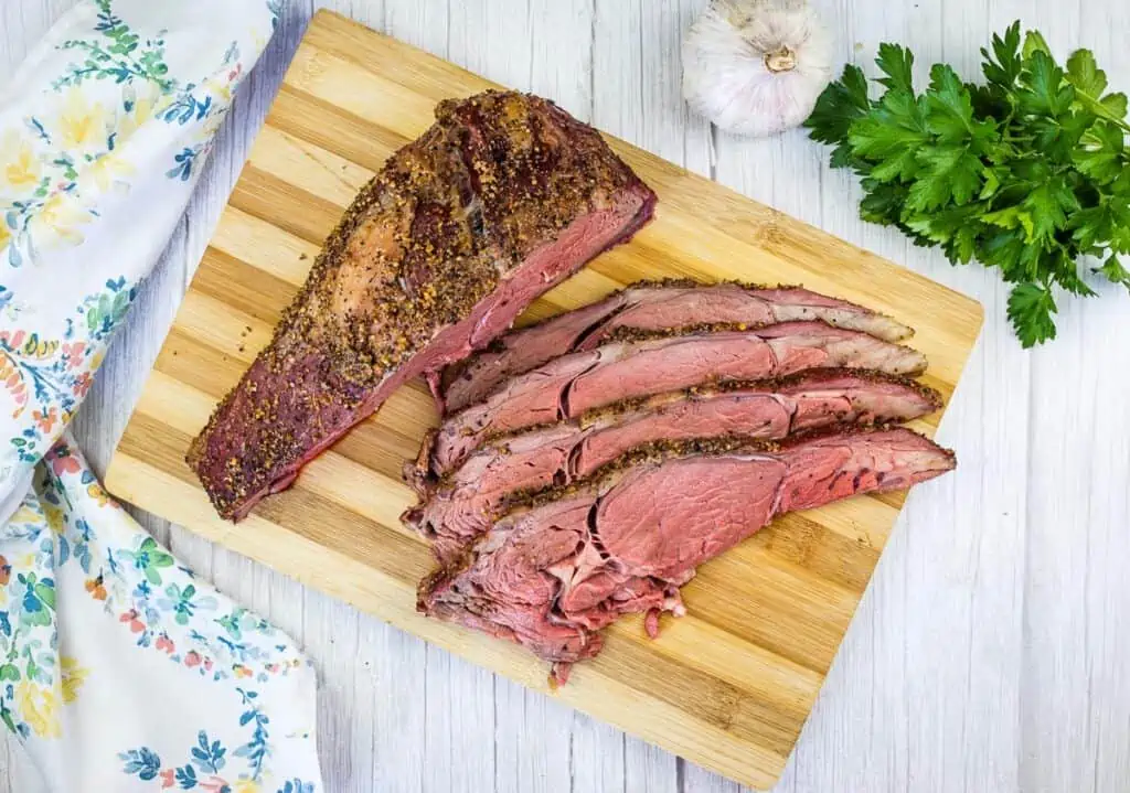 sliced smoked ribeye roast on a cutting board