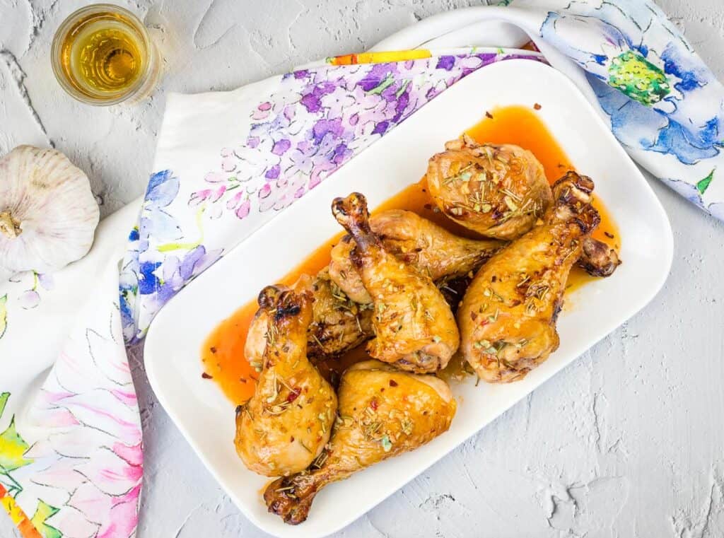 Smoked Chicken Legs with Red Pepper Glaze on a round platter.