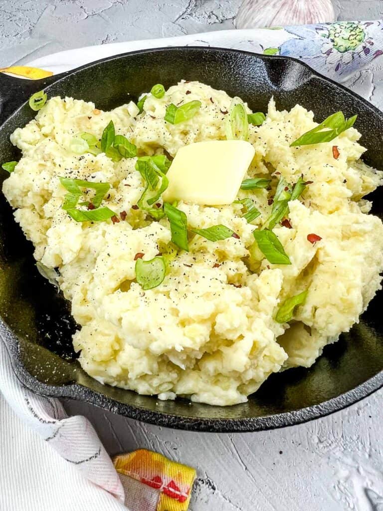a closeup of smoked mashed potatoes in a serving skillet