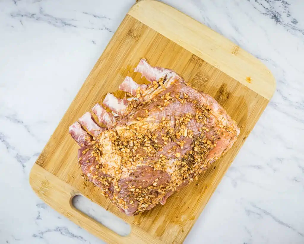 raw rack of pork rubbed and ready for the smoker