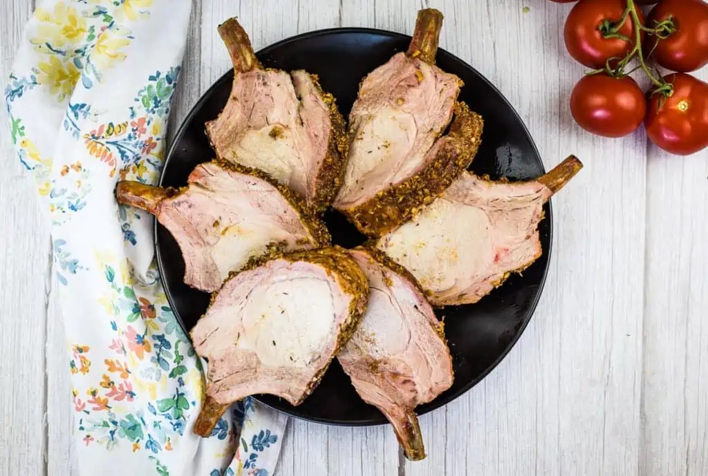 smoked rack of pork fanned out on a black platter