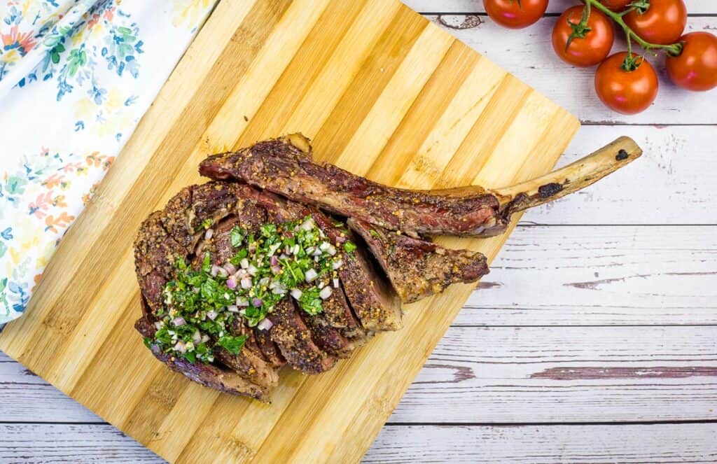 smoked tomahawk steak on a cutting board