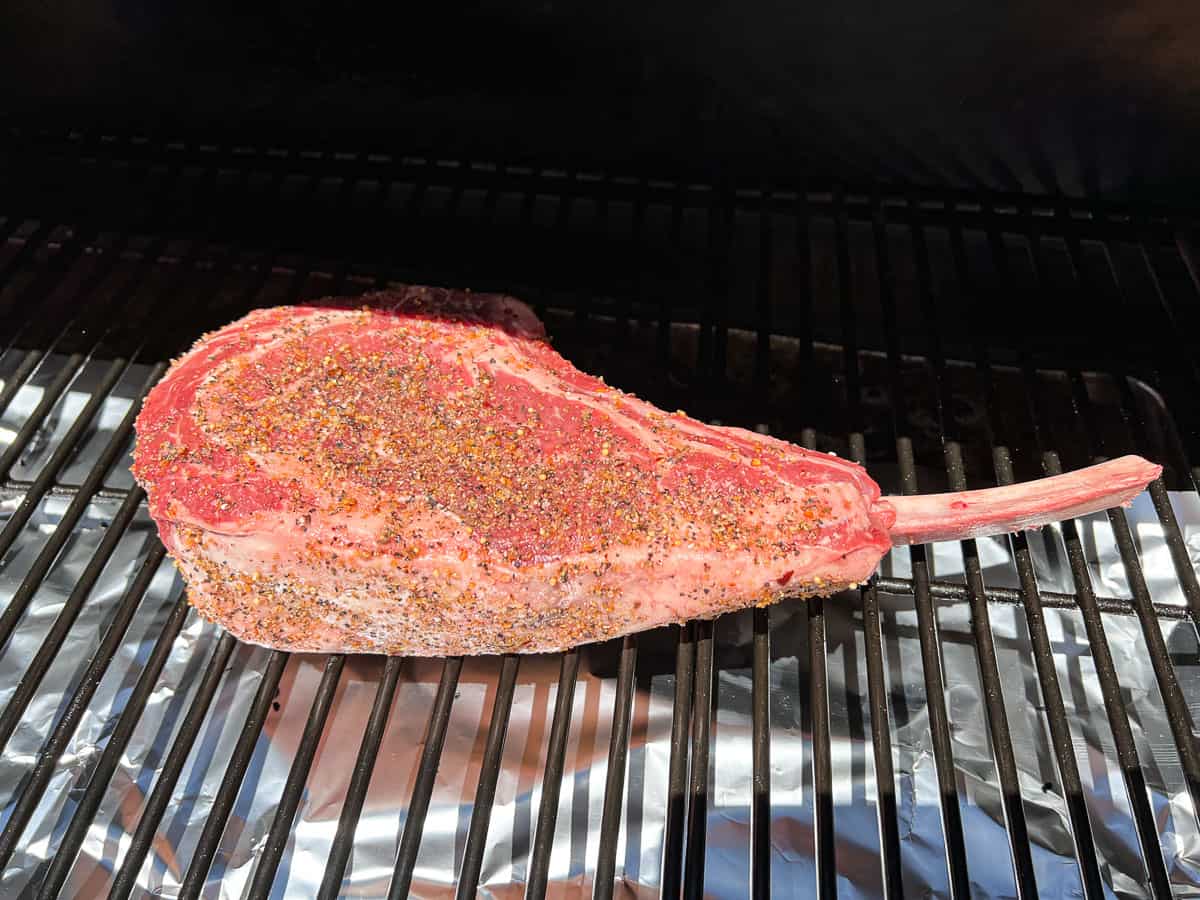 seasoned tomahawk steak on the smoker