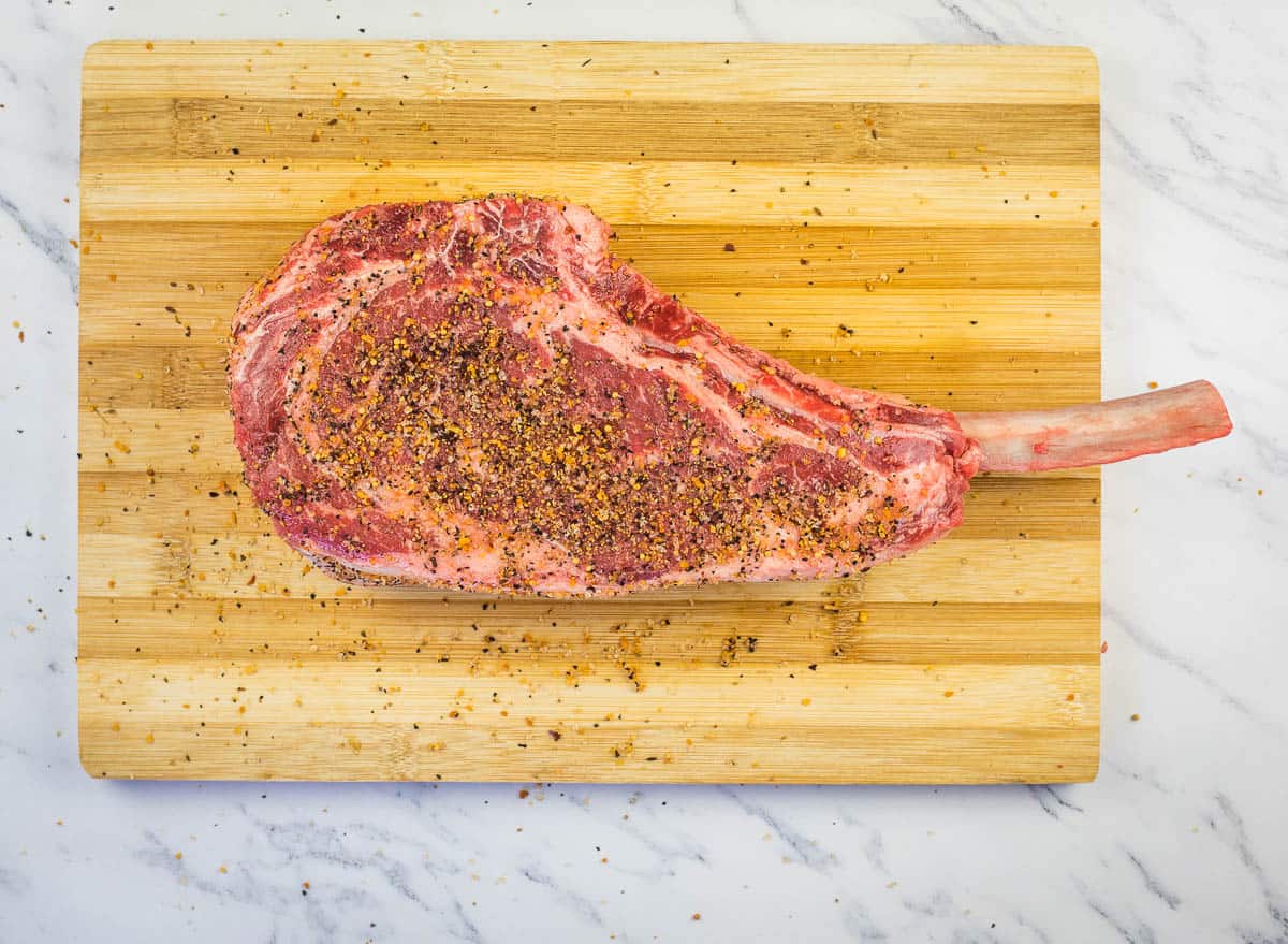 seasoned tomahawk steak on a cutting board