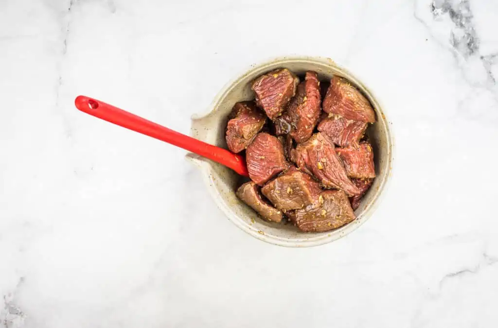 marinating the beef in a bowl