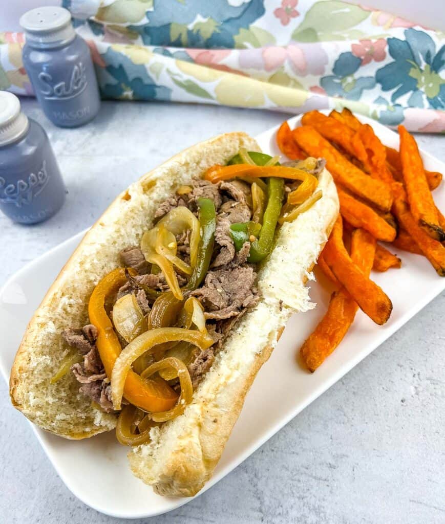 blackstone philly cheesesteaks on a plate with sweet potato fries