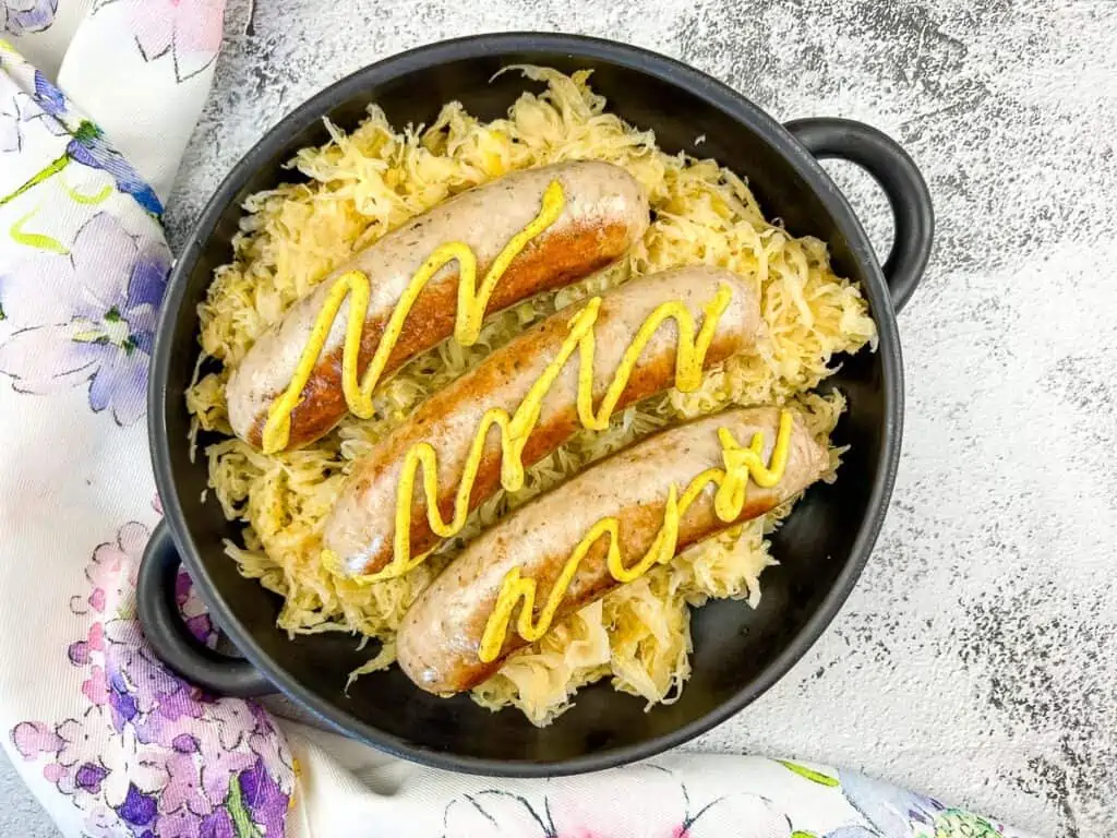 cooked sausage on a blackstone served on top of sauerkraut