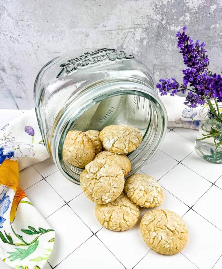 white chocolate crinkle cookies in a glass cookie jar