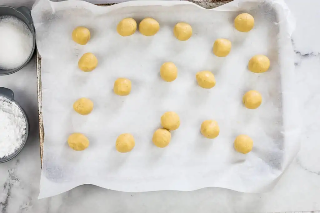 rolled balls of white chocolate crinkle cookie dough