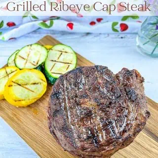 Grilled ribeye cap steaks on a board.