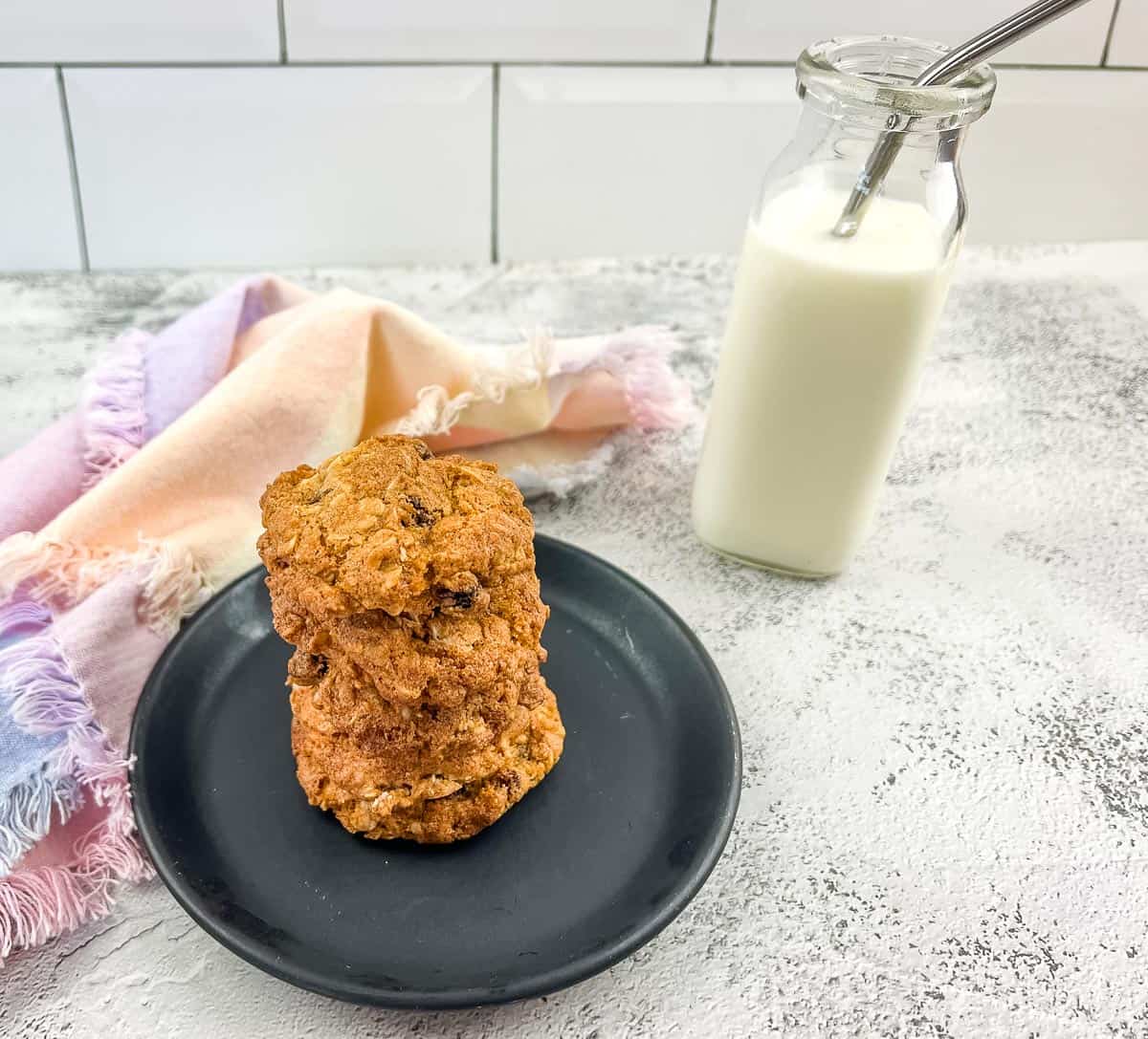 A stack of air fryer oatmeal raisin cookies and a bottle of milk.