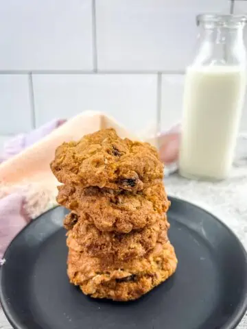 A stack of air fryer oatmeal raisin cookies and a bottle of milk.