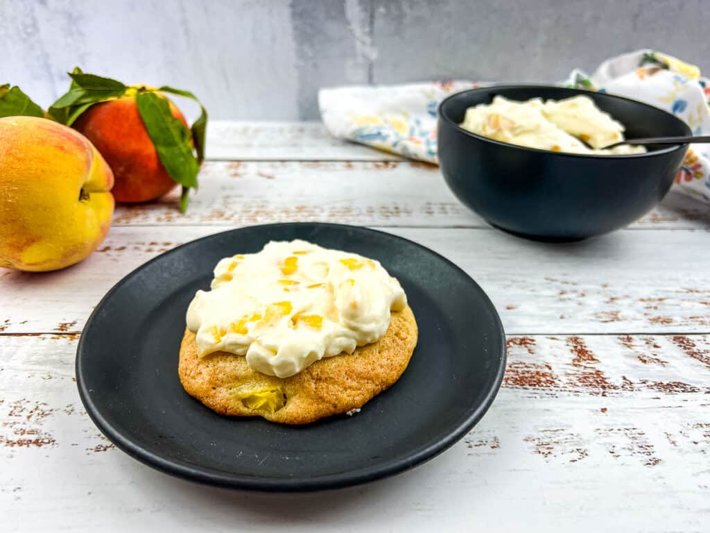 Peach cookies with peaches and cream on a plate.