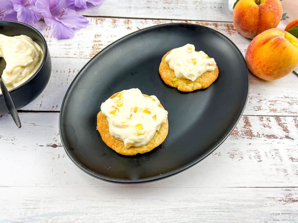 Peaches and cream cookies on a black plate.