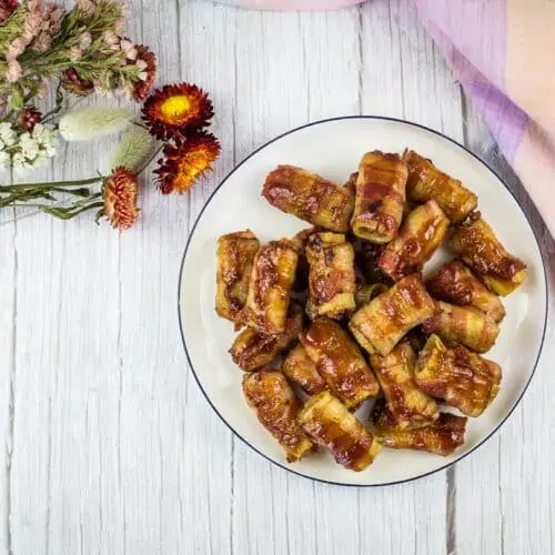 Smoked bullets on a plate with flowers nearby.