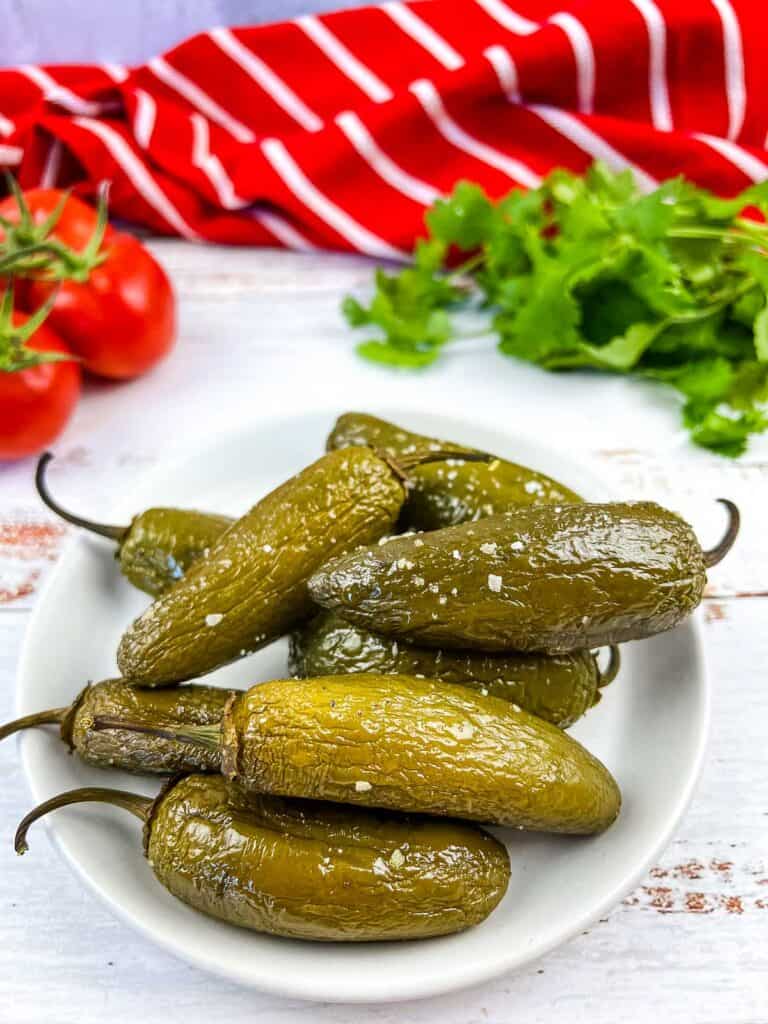 smoked jalapenos on a white plate.