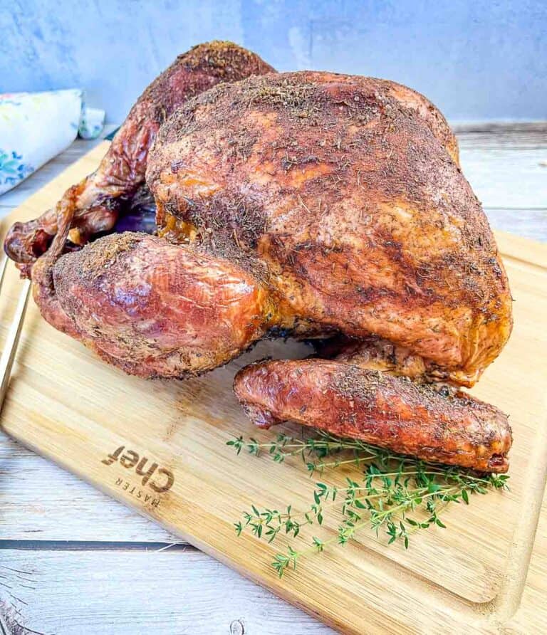 Whole Traeger smoked turkey on a cutting board.