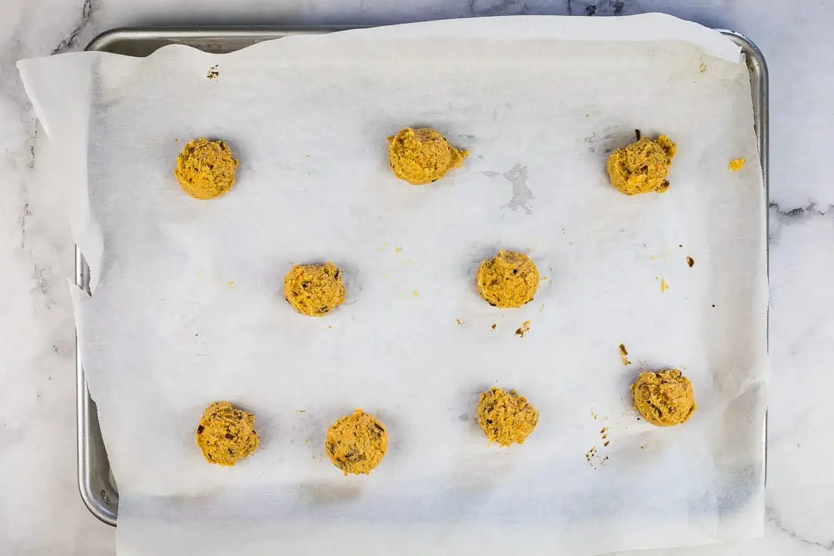 Cookie dough balls on a baking sheet.