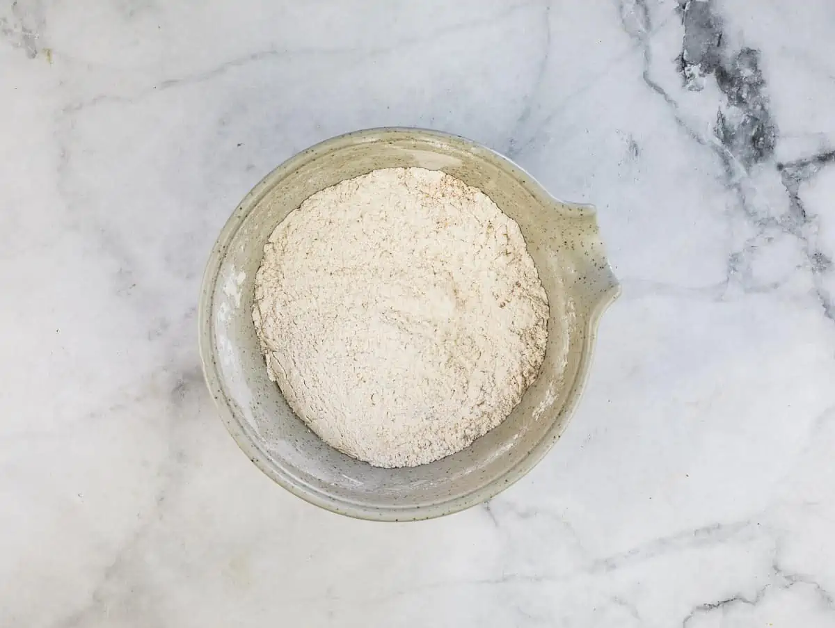 The flour, pumpkin pie spice, baking soda, and salt in a bowl.