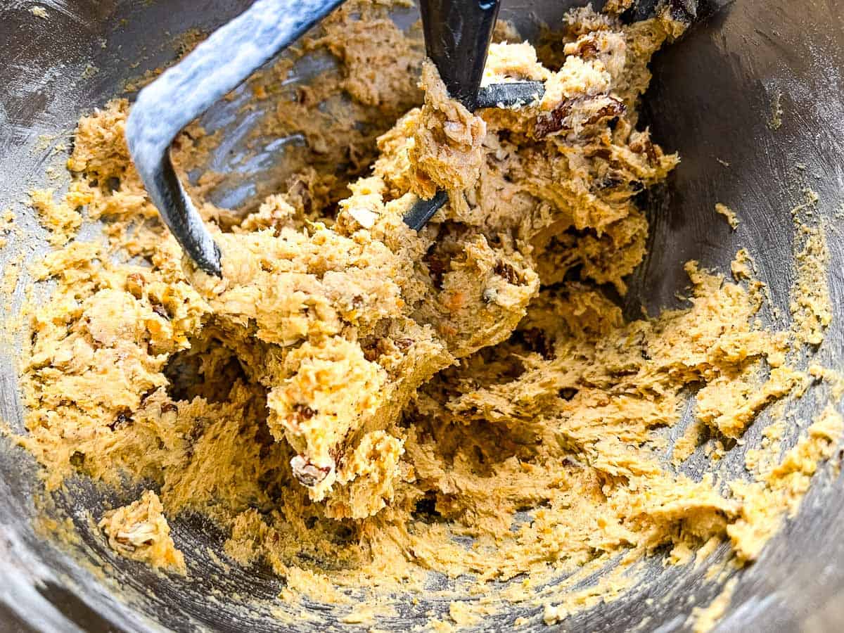 Cookie dough in the bowl of a stand mixer with flour added.
