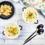 Turkey Pot Pie Soup in two soup bowls with spoons.