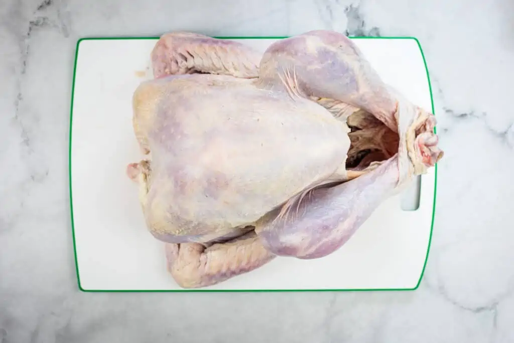 Thawed, raw turkey on a cutting board.