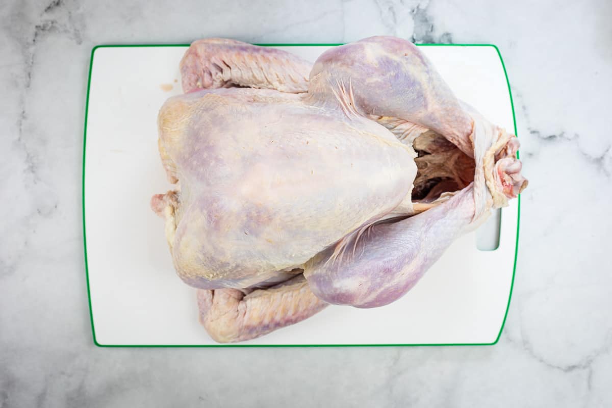 Thawed, raw turkey on a cutting board.