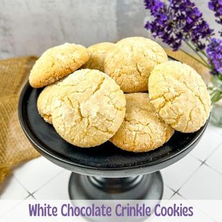 White Chocolate Crinkle Cookies on a black pedestal.