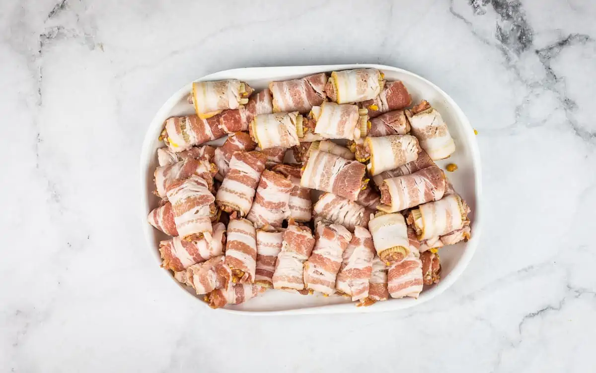 A plate of bacon-wrapped rigatoni noodles.