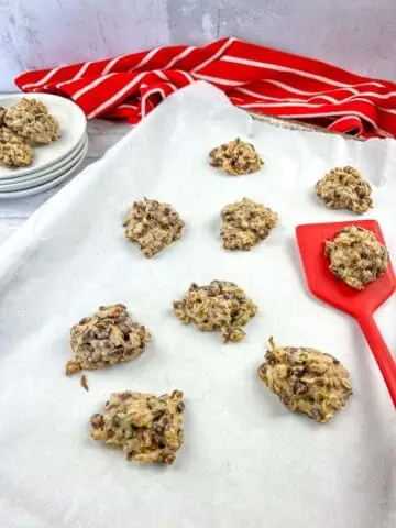 zucchini cookies with chocolate and pecans on a baking sheet with a red flipper