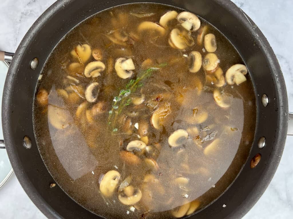 The broth added to the mushrooms and onions.