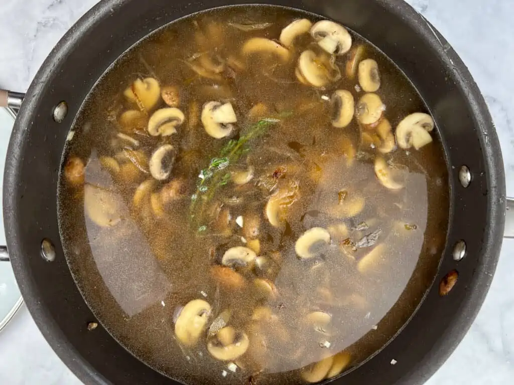 The broth added to the mushrooms and onions.