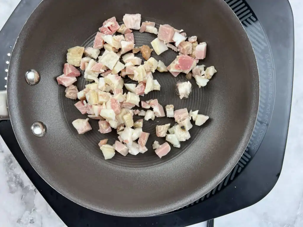 Bacon pan frying in a skillet.